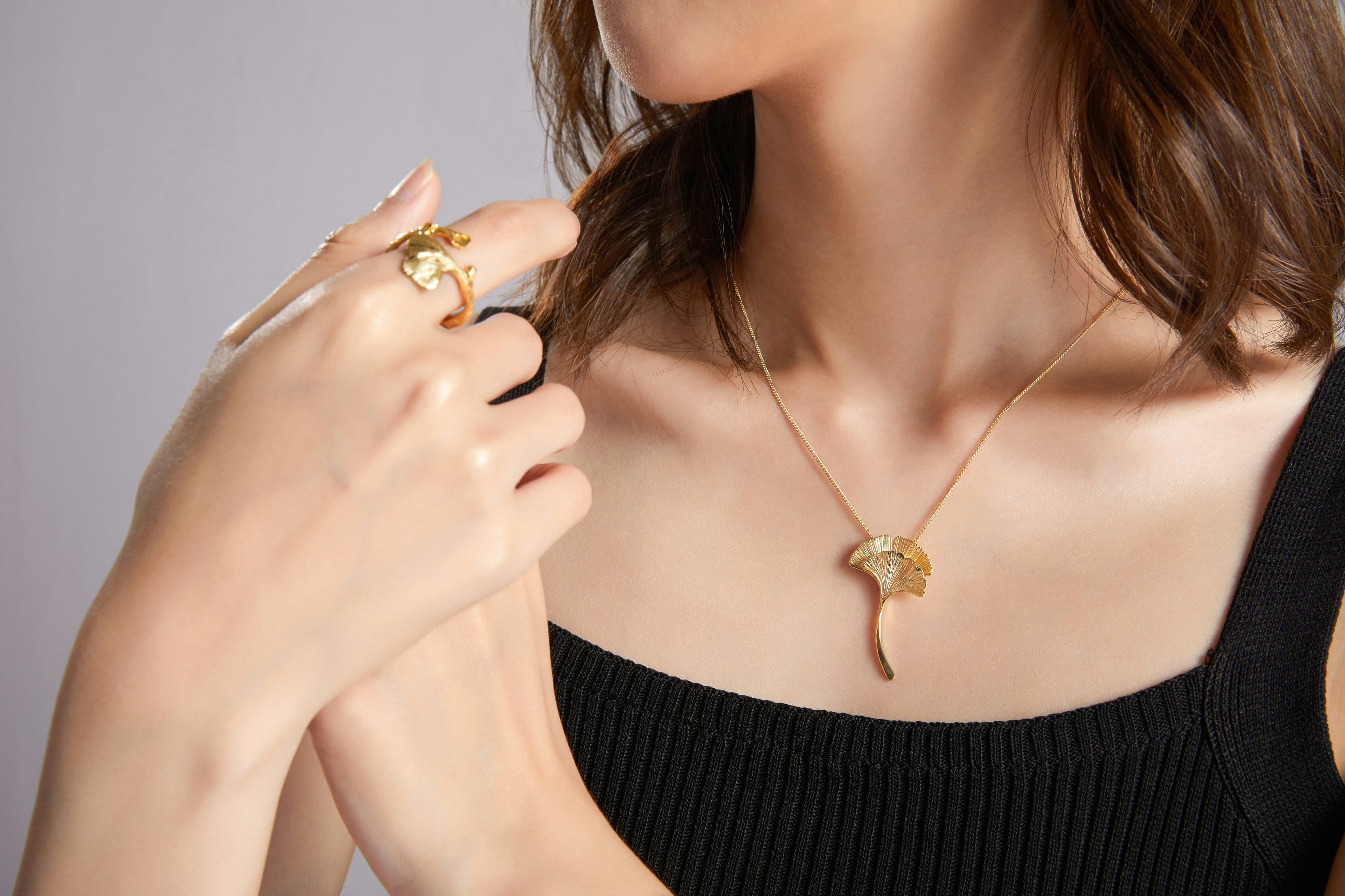 Elegant woman wearing layered gold jewelry in luxury jewelry store